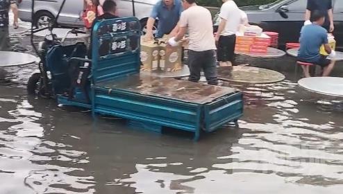 河南大暴雨宾客坐积水中吃席，积水高达膝盖位置